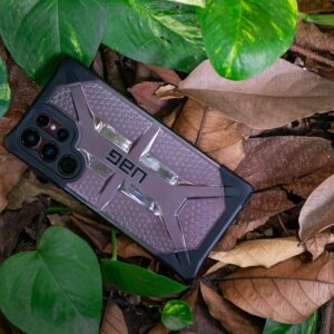 High-quality Urban Armor Gear phone case on a forest floor in Ho Chi Minh City, surrounded by leaves.